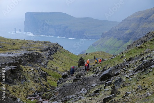 Mountain trip from Saksun village of Saksun to Tjornuvik on island of Streymoy. Silhouettes of hiking people on trail. Faroe Islands, Denmark photo