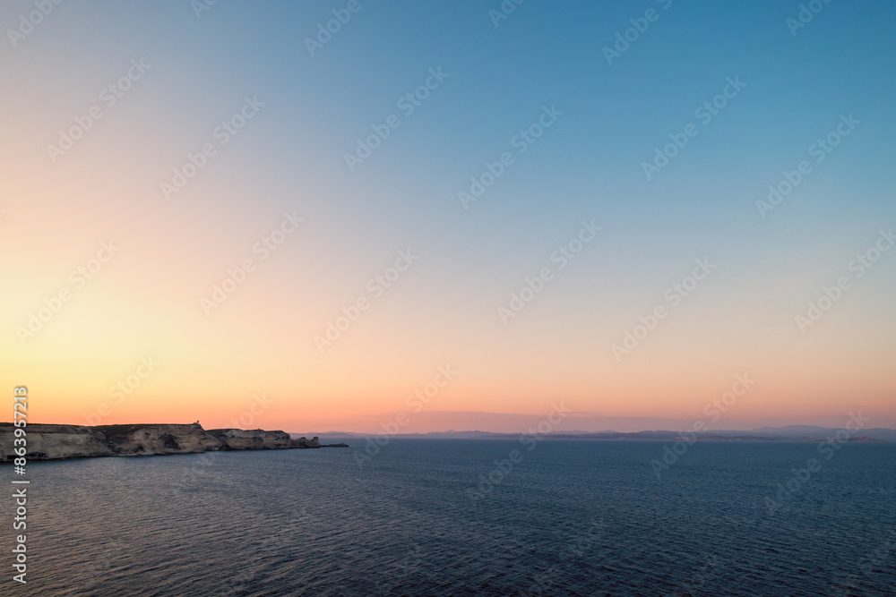 Dawn breaking over the cliffs of Bonifacio and Mediterranean sea on the south coast of Corsica with the coastline of Sardinia in the distance Dawn breaking over the cliffs of Bonifacio and Mediterranean sea on the south coast of Corsica with the coastline of Sardinia in the distance