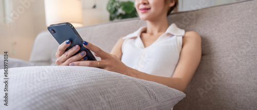 Woman Relax on Couch Using Smartphone for Social Media in Modern Living Room Setting