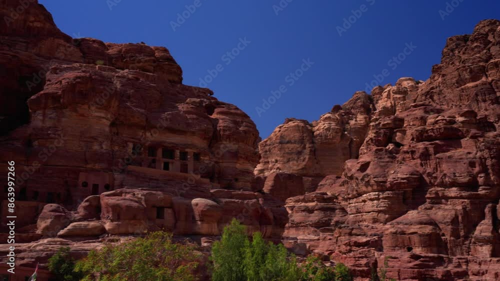 View of the narrow Siq canyon pathway leading to Petra, Jordan, with towering sandstone cliffs. View of the narrow Siq canyon pathway leading to Petra, Jordan, with towering sandstone cliffs.