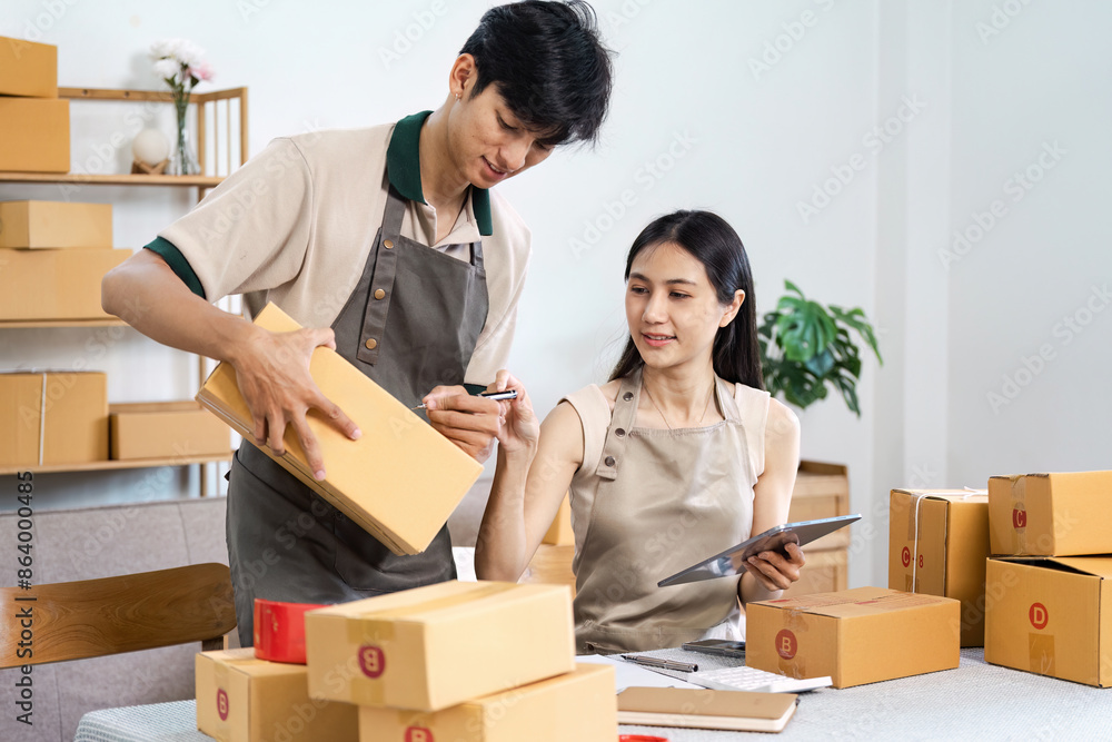 Young Entrepreneur Working Together in a Modern Small Business Packaging and Shipping Products Young Entrepreneur Working Together in a Modern Small Business Packaging and Shipping Products