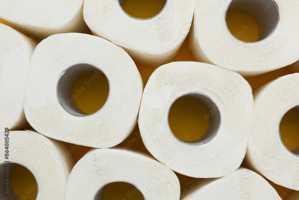 Lots of toilet paper rolls on yellow background. Top view