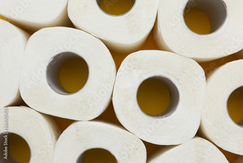 Lots of toilet paper rolls on yellow background. Top view