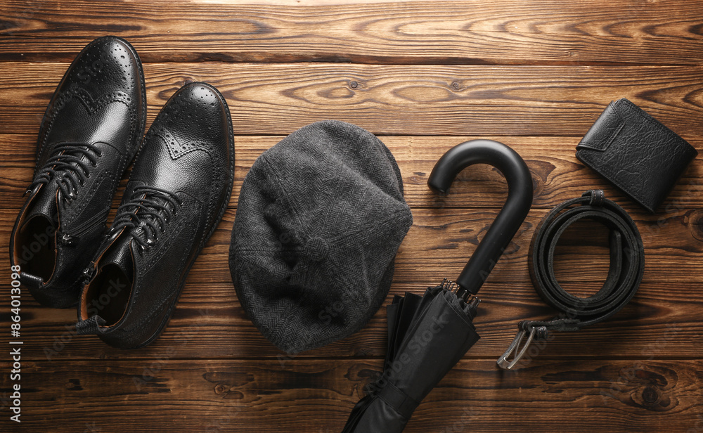 Gentleman's accessories. Men's boots, cap and umbrella, belt, wallet on a wooden background. Flat lay Gentleman's accessories. Men's boots, cap and umbrella, belt, wallet on a wooden background. Flat lay