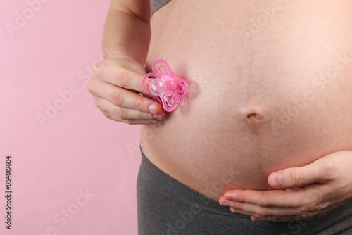 Wallpaper Mural Pregnant woman holding pacifier on pink background Torontodigital.ca
