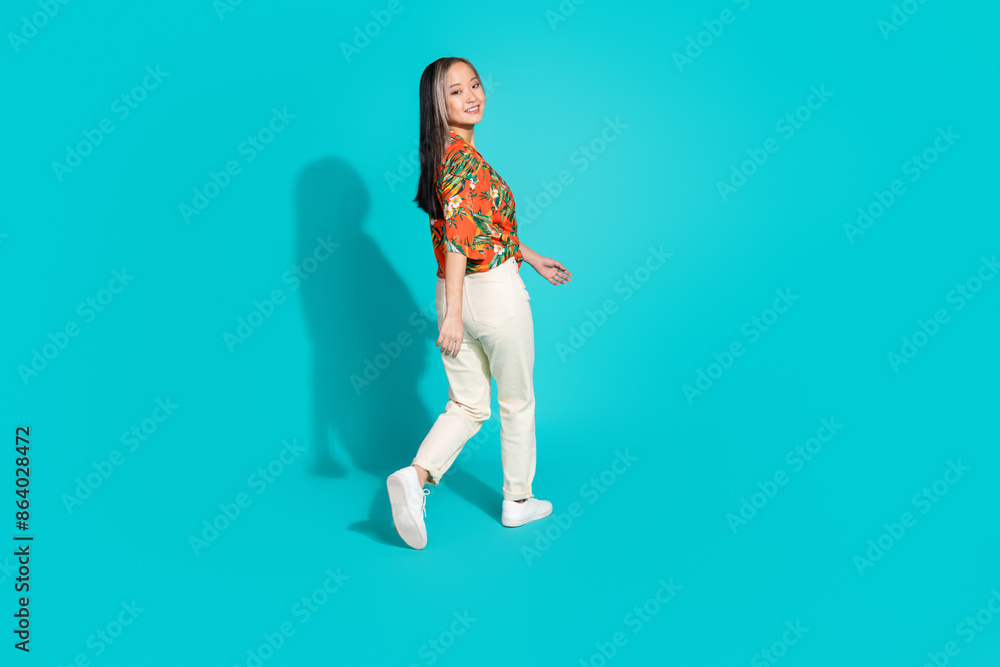 Full length photo of cute lovely girl wear floral shirt walking empty space isolated teal color background Full length photo of cute lovely girl wear floral shirt walking empty space isolated teal color background