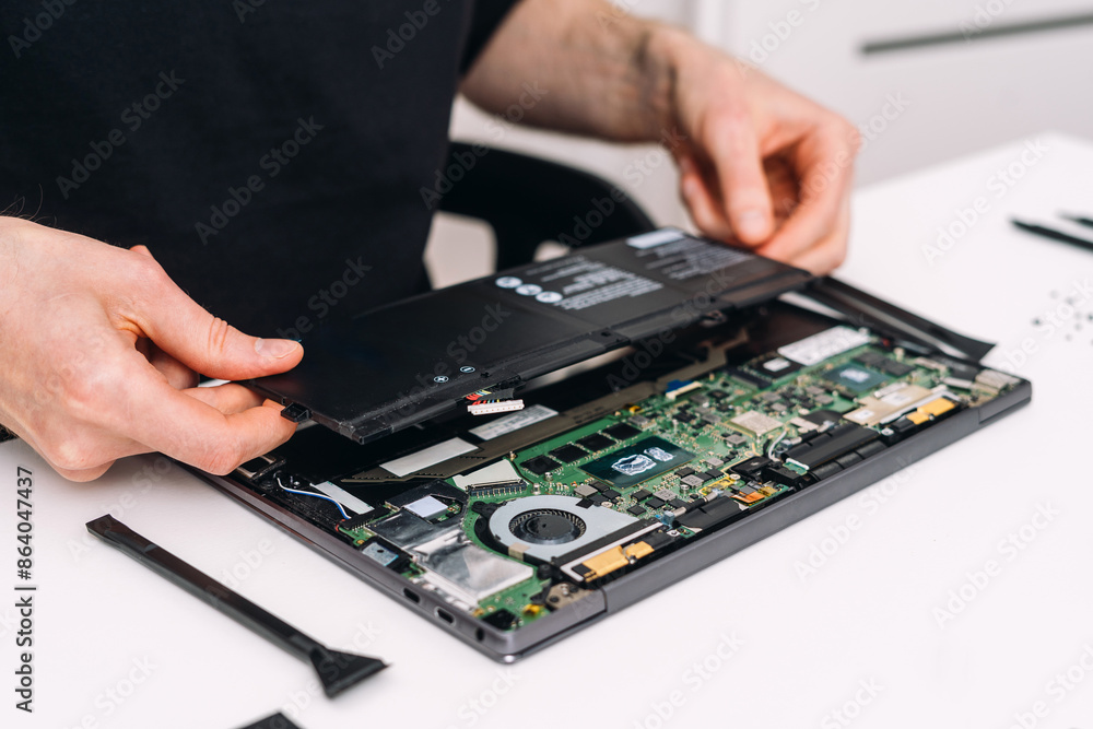 Technician change laptop battery at computer repair service Technician change laptop battery at computer repair service