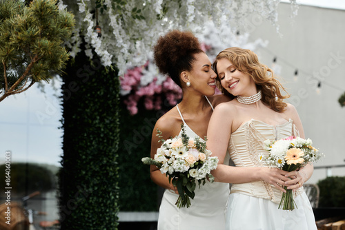 Two brides share a tender moment during their wedding ceremony.