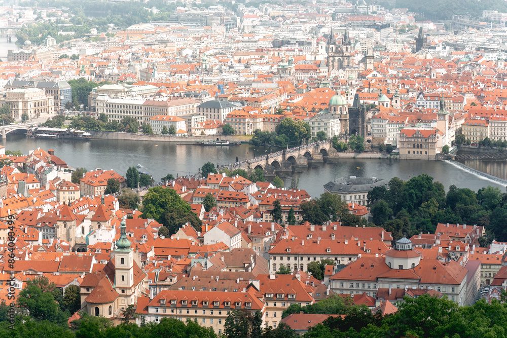 Obraz premium Aerial view of Prague's cityscape, showcasing its traditional architecture and the iconic Charles Bridge spanning the Vltava river