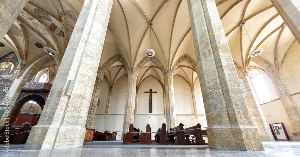 Fototapeta premium Inside a Emmaus Monastery featuring towering stone columns and an arched ceiling