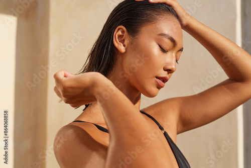 Hair Care. Woman Enjoying Sunlight With Closed Eyes, Relaxed Expression, And Wet Hair, Embracing Natural Beauty. photo