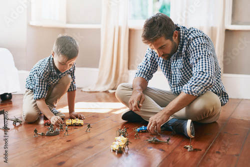 Dad, son and playing with toys on floor for bonding, activity or imagination at home. Father with young child, kid or little boy with action figures, solidiers or cars for fun games at house photo