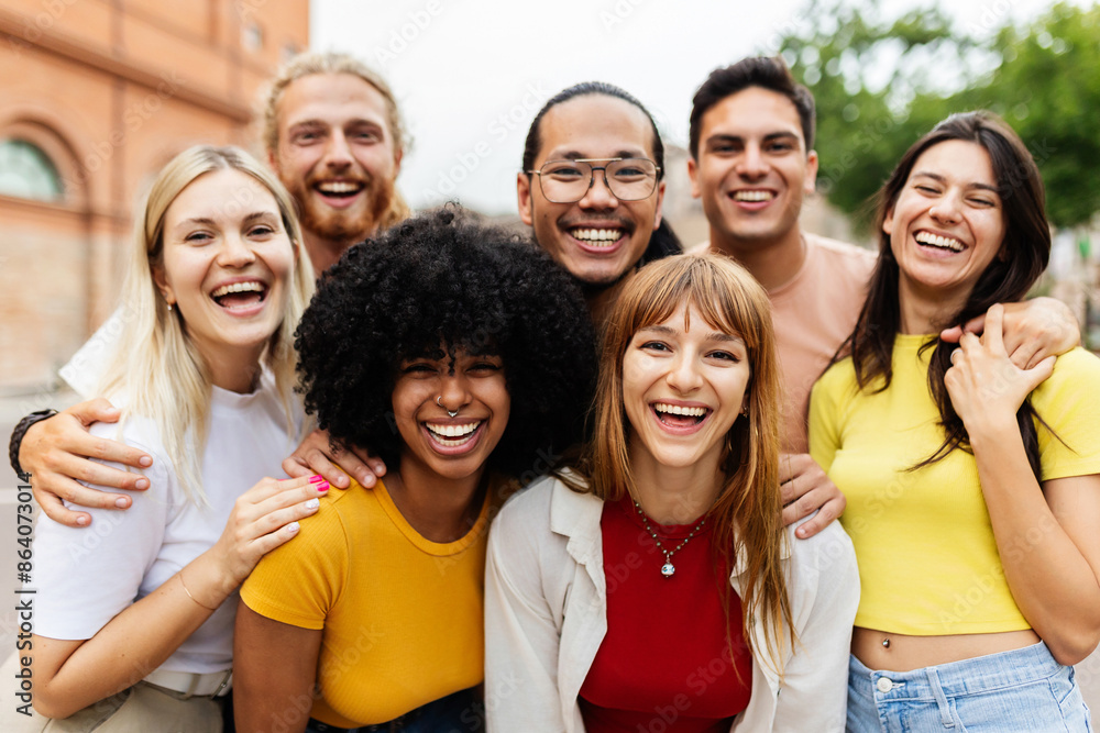 Portrait group of diverse young friends smiling at camera at city street. Multiracial millennial student people showing unity standing together outside. Youth community and friendship concept. Portrait group of diverse young friends smiling at camera at city street. Multiracial millennial student people showing unity standing together outside. Youth community and friendship concept.