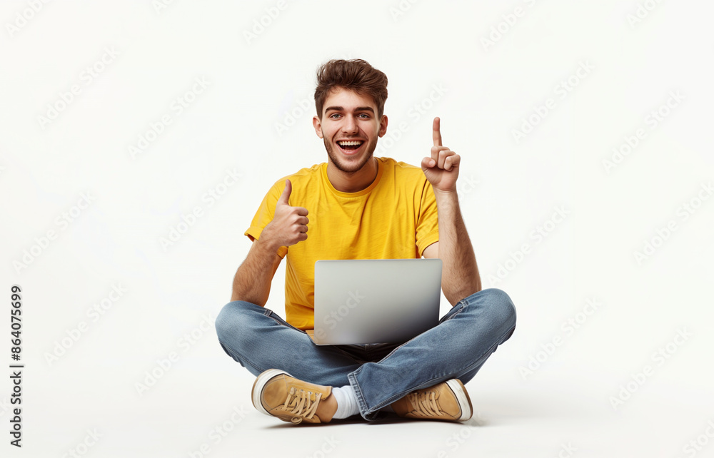 Portrait of a happy young man in casual holding laptop computer while sitting on a floor isolated on white background. Pointing finger Portrait of a happy young man in casual holding laptop computer while sitting on a floor isolated on white background. Pointing finger