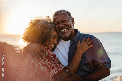 Foto Elderly couple embracing at sunset, sharing joy and love by the seaside