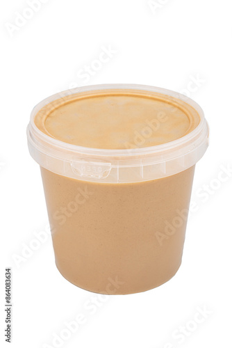 Tahini per kilo in a plastic bowl. Tahini paste jar. Isolated on white background. photo
