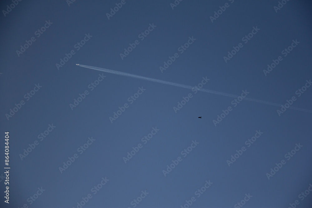 Airplane flight in the sky and the line that forms behind it (contrail) Airplane flight in the sky and the line that forms behind it (contrail)