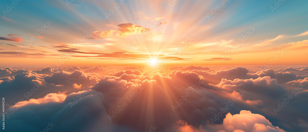 Obraz premium Breathtaking sunrise over fluffy clouds fills the sky with vibrant colors and warmth, offering a serene and inspiring start to the day.