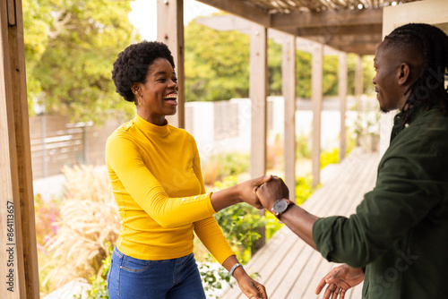 Outdoors, Couple smiling and greeting each other with handshake on porch at home photo