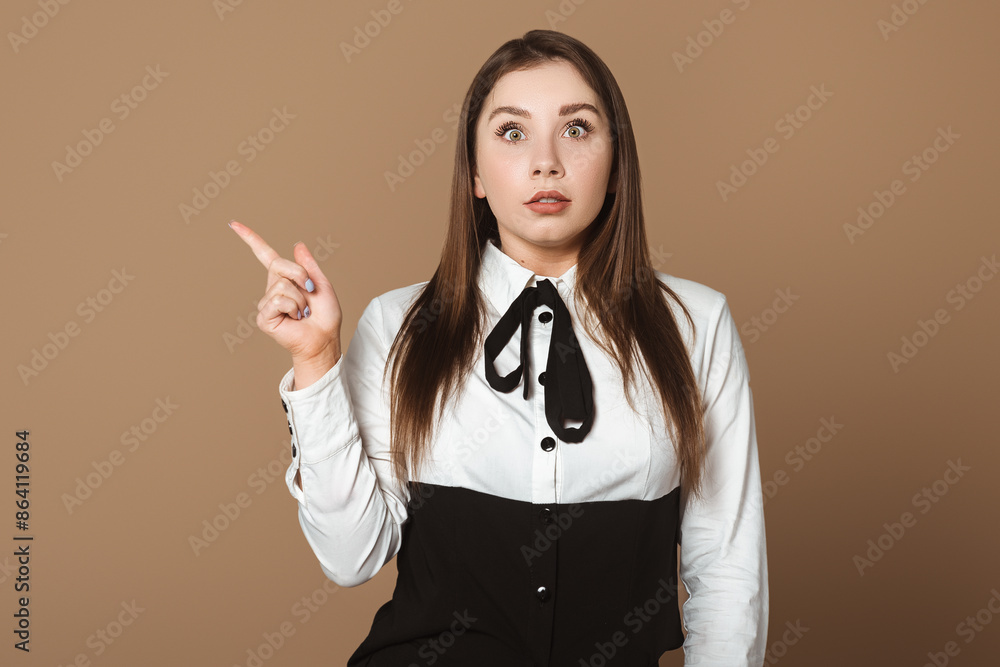 Surprised Young Woman Pointing Up. Expressive Gesture of Amazement. Copy Space for Text Surprised Young Woman Pointing Up. Expressive Gesture of Amazement. Copy Space for Text