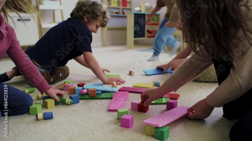 Children running into the classroom and playing with toy blocks 