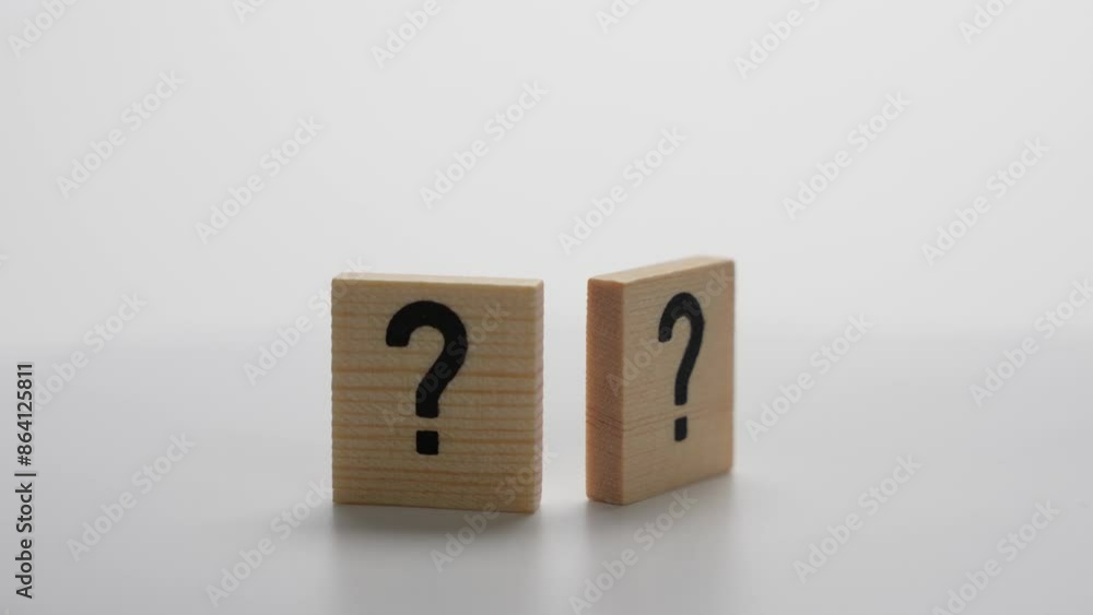 Two wooden blocks with a question mark on them. The blocks are placed next to each other on a white surface Two wooden blocks with a question mark on them. The blocks are placed next to each other on a white surface