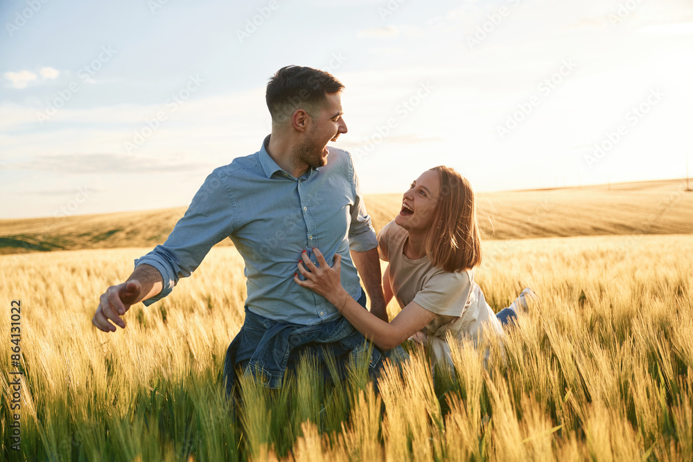 Leading the way, holding hands. Lovely beautiful couple are together on the agricultural field Leading the way, holding hands. Lovely beautiful couple are together on the agricultural field