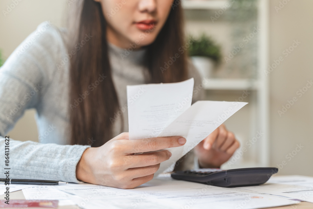 Financial owe, hand of asian woman sitting, holding credit card, stressed by calculate expense from invoice or bill, no money to pay, mortgage or loan Financial owe, hand of asian woman sitting, holding credit card, stressed by calculate expense from invoice or bill, no money to pay, mortgage or loan