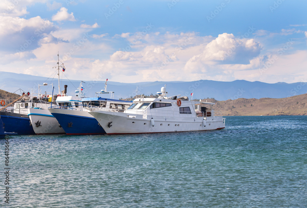 Baikal Lake in Summer. Beautiful seascape with ships on the pier in the village of Sakhyurta on a sunny day. Summer cruises and travel Baikal Lake in Summer. Beautiful seascape with ships on the pier in the village of Sakhyurta on a sunny day. Summer cruises and travel