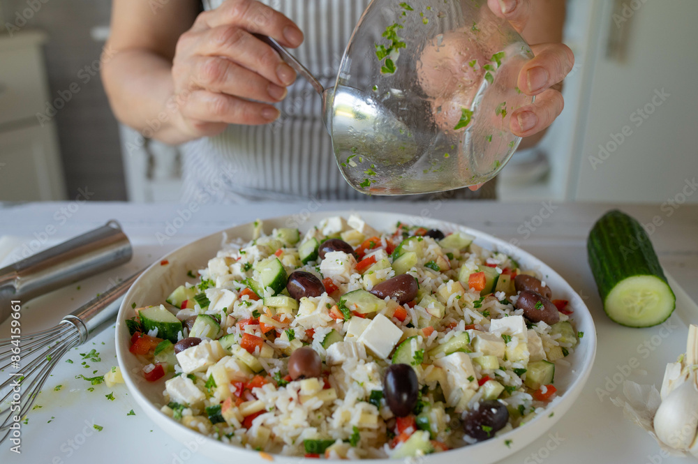 Marinating a fresh and homemade salad by woman´s hand on kitchen counter Marinating a fresh and homemade salad by woman´s hand on kitchen counter