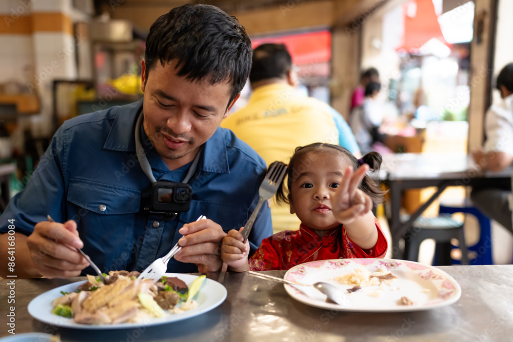Adorable little asian girl eat steam rice with dad on street food local city Yaowarat Adorable little asian girl eat steam rice with dad on street food local city Yaowarat