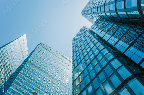 Low angle view of skyscraper with glass window and clear blue sky background for business and finance concept	