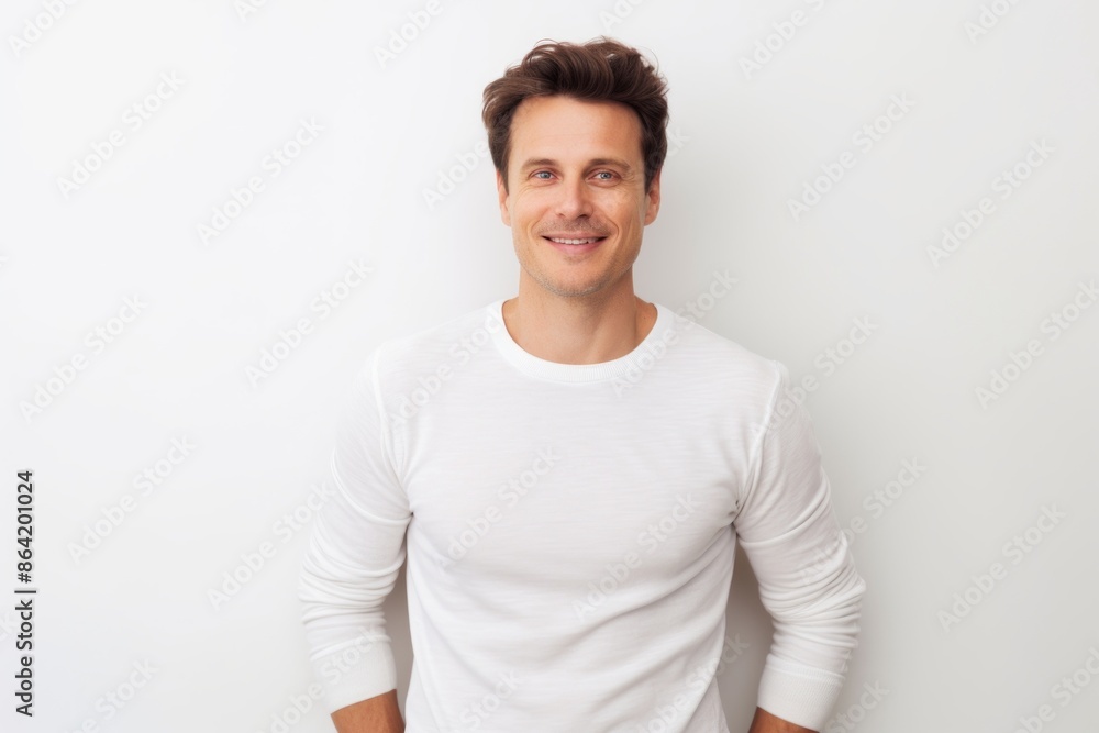 Obraz premium Portrait of a tender man in his 30s showing off a thermal merino wool top on white background