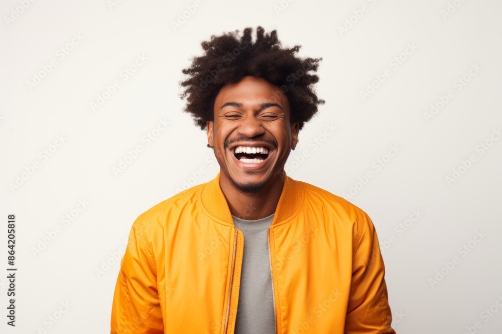 Portrait of a joyful afro-american man in his 20s wearing a trendy bomber jacket on white background Portrait of a joyful afro-american man in his 20s wearing a trendy bomber jacket on white background