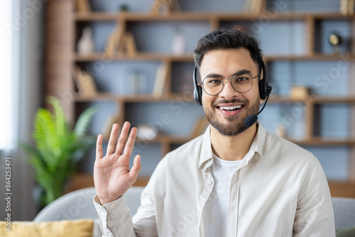 Photography Close-up photo of a young Muslim man wearing glasses and a headset at home, talk