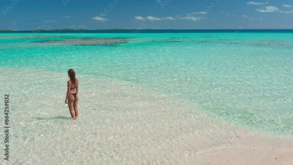 Woman standing on a beach next to yellow kayak. Travel summer background - small tropical island in turquoise water coral reef sea. Perfect sand beach drone flight Woman standing on a beach next to yellow kayak. Travel summer background - small tropical island in turquoise water coral reef sea. Perfect sand beach drone flight