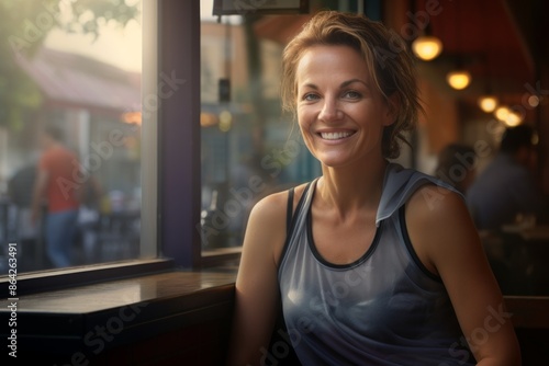 Portrait of a happy woman in her 40s sporting a breathable mesh jersey over bustling city cafe