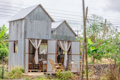 The background of the park decoration has a corner table and wooden chairs for sitting and relaxing during the day. Amidst the various flowers, the beauty of the green grass.