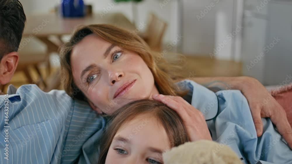 Relaxed mother watching movie on tv sitting couch with husband daughter closeup Relaxed mother watching movie on tv sitting couch with husband daughter closeup