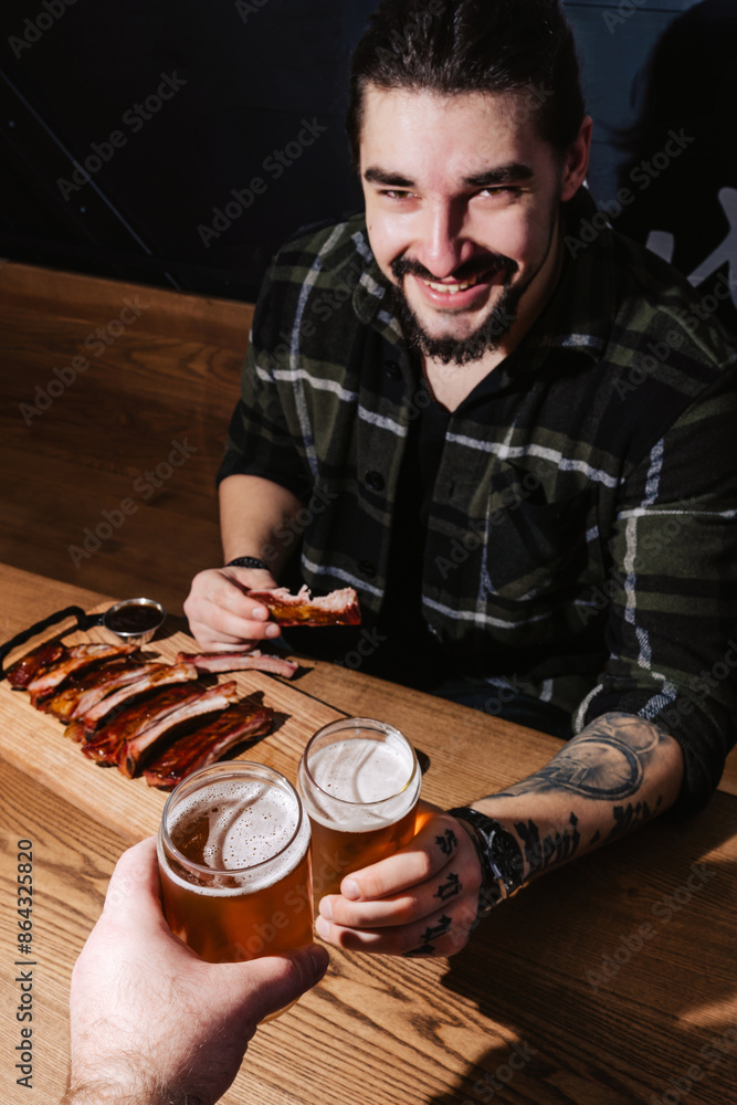 Friendly man enjoys ribs and beer at a barbecue restaurant Friendly man enjoys ribs and beer at a barbecue restaurant