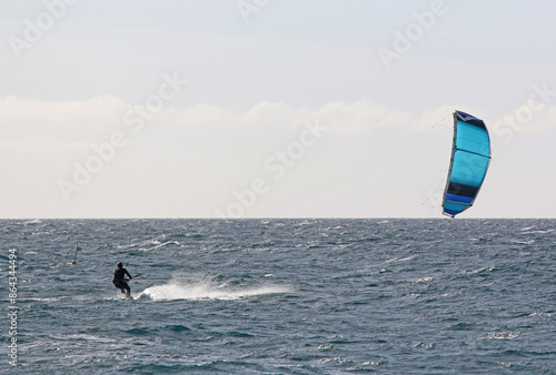 Kitesurfer riding his board in waves	