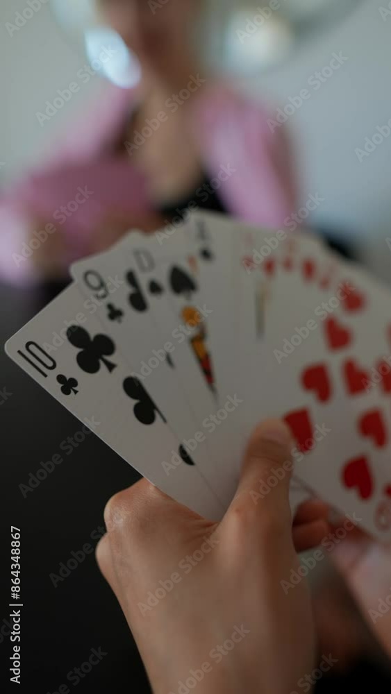 Two women are relaxed, playing cards, bonding through friendly competition and casual interaction Two women are relaxed, playing cards, bonding through friendly competition and casual interaction