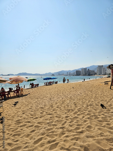 Vertical view of Icacos beach in Acapulco, with umbrellas and tourists, Mexico photo