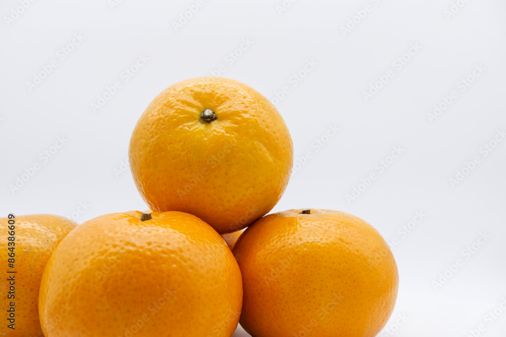 Mandarin oranges stacked together with a white background. Organic and fresh ripe fruit for healthy eating. Close-up ripe orange fruit texture with copy space. Still-life fruit with white background. Mandarin oranges stacked together with a white background. Organic and fresh ripe fruit for healthy eating. Close-up ripe orange fruit texture with copy space. Still-life fruit with white background.