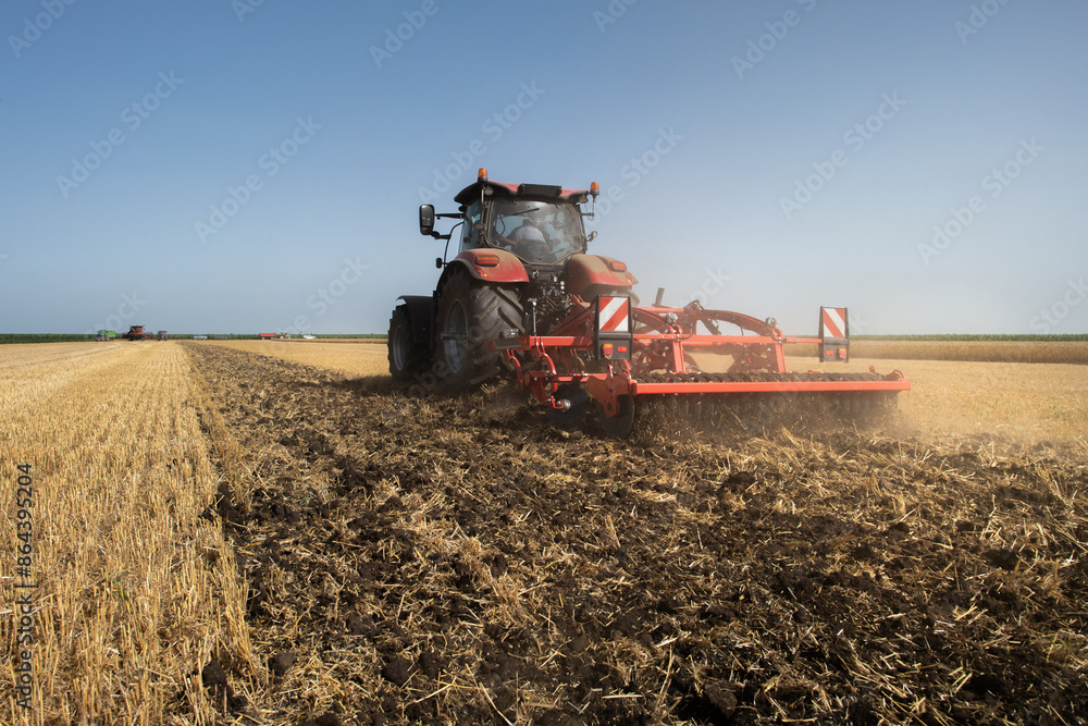 Fototapeta premium Tractor preparing land with seedbed cultivator.
