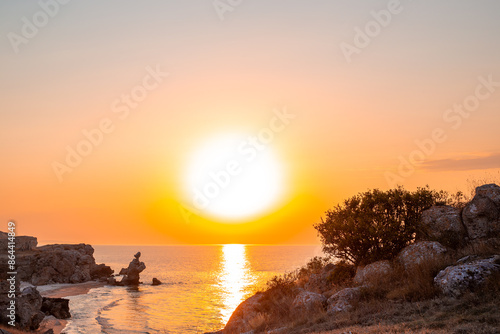 The sea evening landscape. The sea at sunset and the rocky shore on a summer day. The coast of Crimea, the Sea of Azov, the General beaches photo