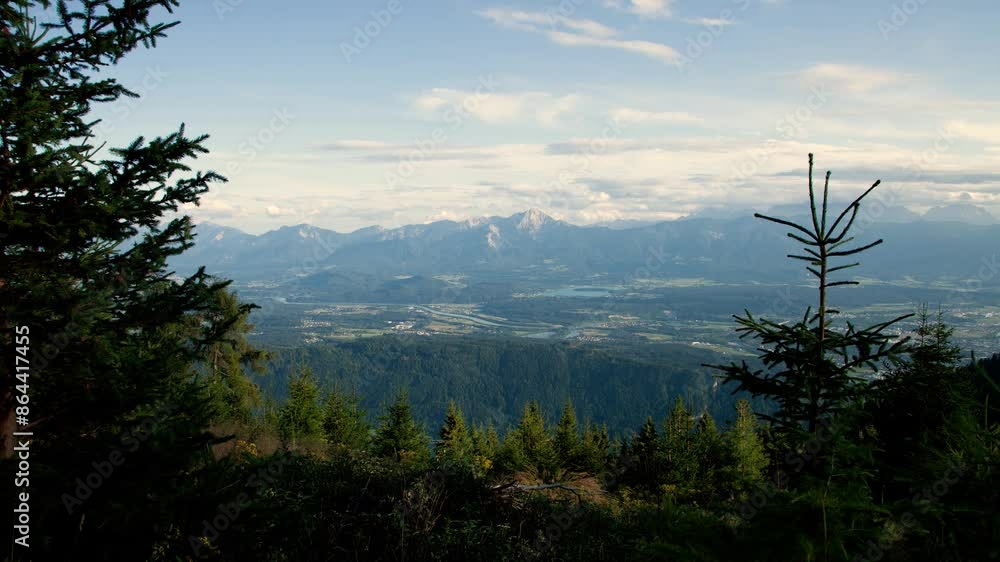 Timelapse moving backward in the valley of Villach in Austrian Alps with a pine forest and clouds Timelapse moving backward in the valley of Villach in Austrian Alps with a pine forest and clouds