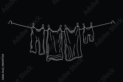 Clothesline with hanging clothes drying on rope in laundry room