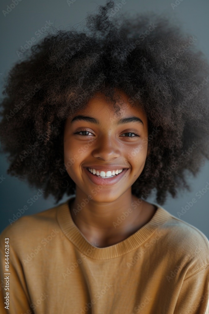 A young woman with an afro hairstyle smiles directly at the camera A young woman with an afro hairstyle smiles directly at the camera