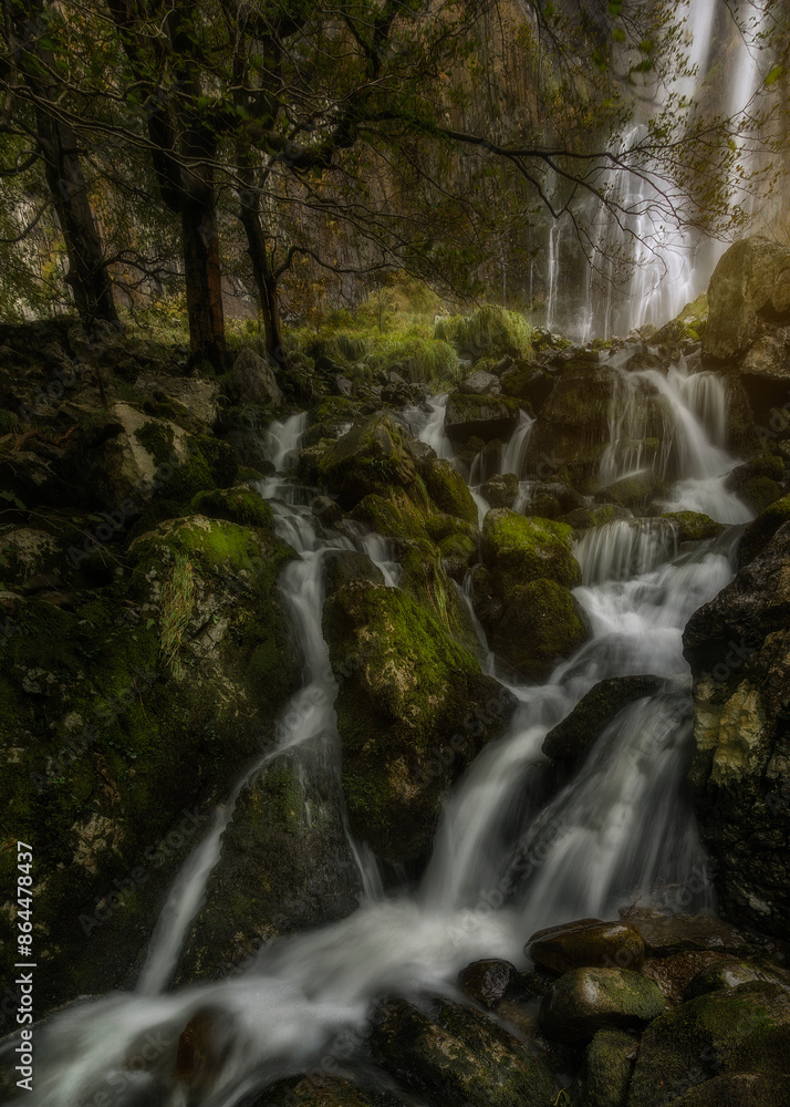 Detail of the waterfalls at the source of the Ason River in Cantabria, between rocks covered with moss inside a beech forest Detail of the waterfalls at the source of the Ason River in Cantabria, between rocks covered with moss inside a beech forest